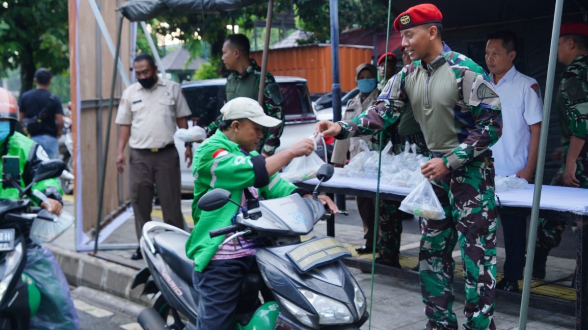 Anggota Kopassus memberikan takjil kepada driver ojek online di Jakarta, Jumat (31/3/2023).